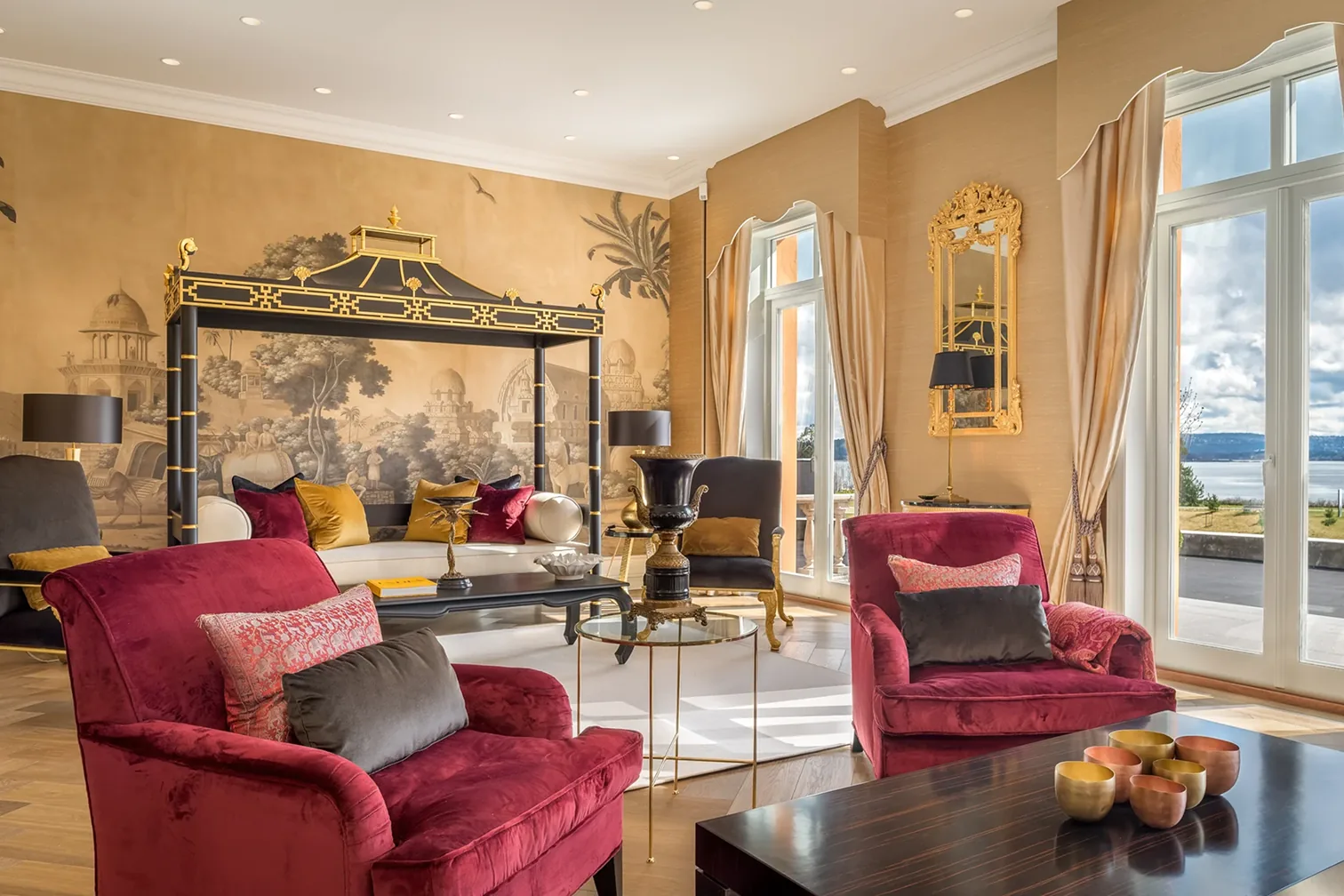 Stemningsfull lounge med lenestoler og dekket tebord i dagslys på Chitra House