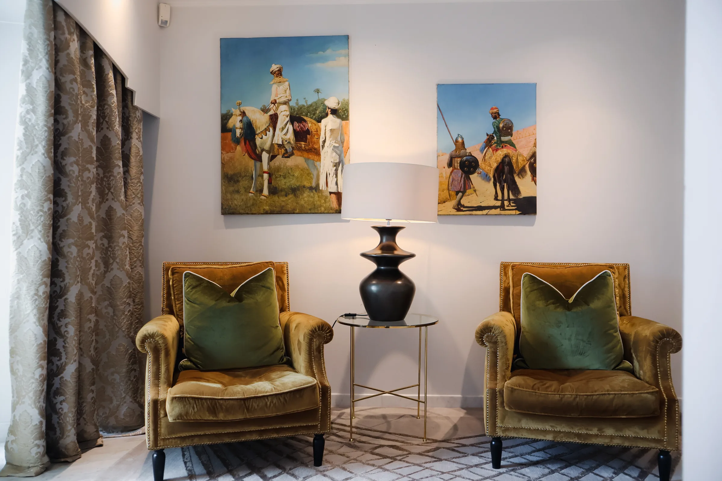 Sittegruppe med lenestoler og malerier i 2. etasje på Chitra House